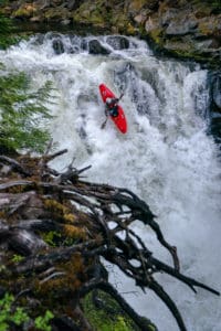 Kayaker flowing off a waterfall.