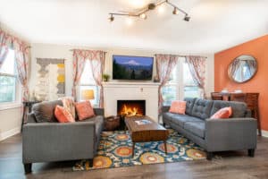 A well decorated brights remodel living room with two couches, fireplace, and nice accents.