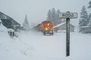 A train blast through fresh snow following a snowstorm.
