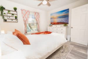 Bright and inviting bedroom with colorful accents and beach photo on the wall.