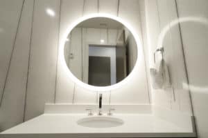 Modern bathroom circular mirror with ring light reflection.