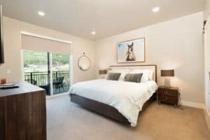 Stylish master bedroom with king bed and horse painting on the wall.